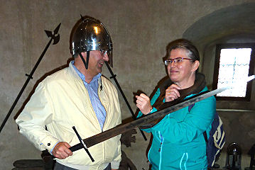 Touristen beim Ausprobieren mittelalterlicher Exponate in der Wasserburg Heidenreichstein